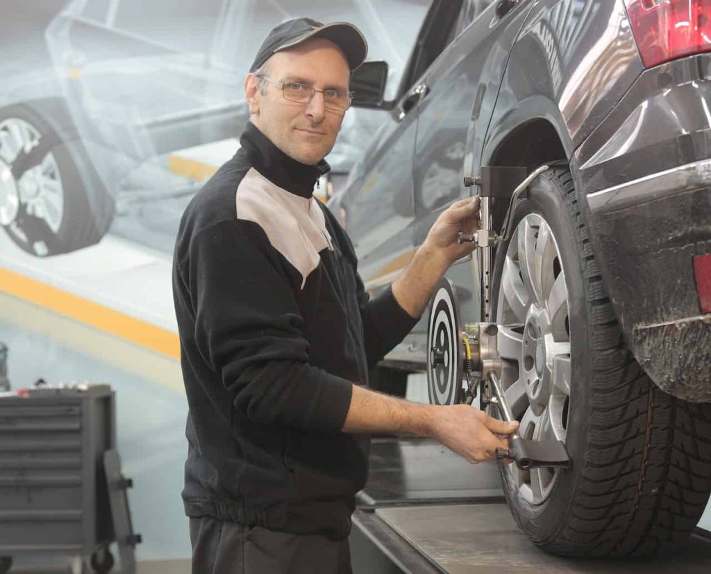 MAN USING WHEEL ALIGNMENT MACHINE