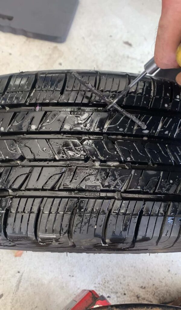 INSERTING A TIRE PLUG INTO TIRE PUNCTURE